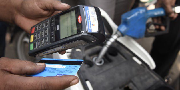 Person using credit card to pay for fuel showing India's move towards a cashless system