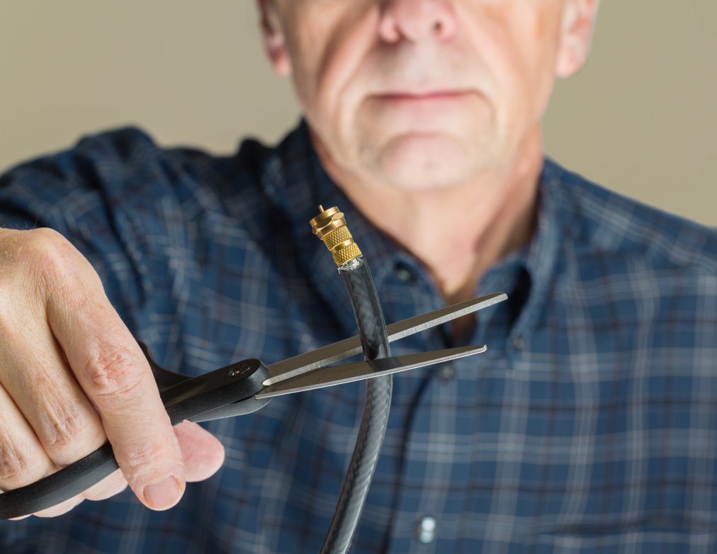 Cutting the cable connection to coax connector illustrating retired people cancelling cable TV service