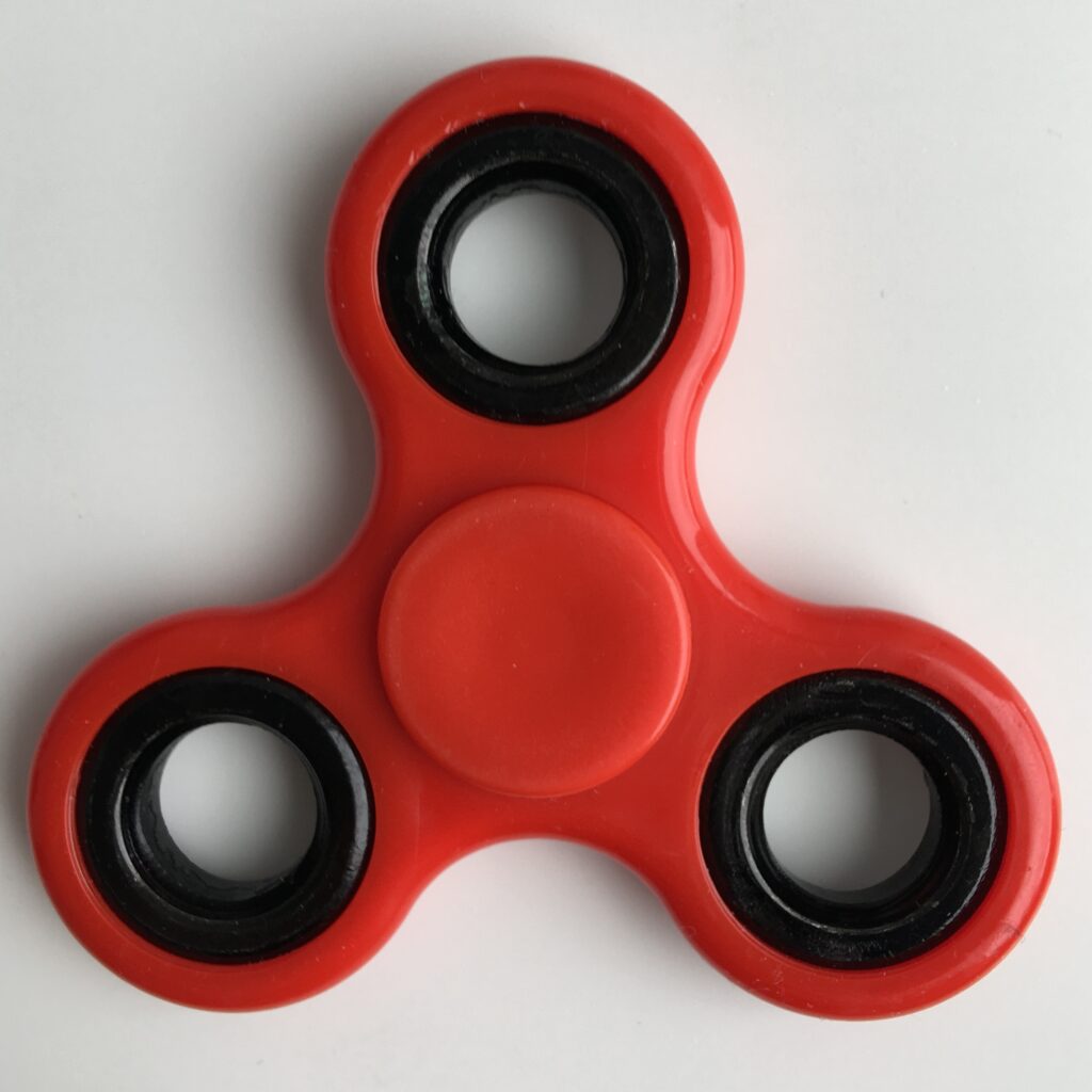 A photograph of a red fidget spinner