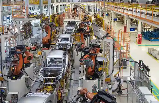 Physical AI industrial robotic arms assembling electric vehicle components in a Japanese automotive factory.